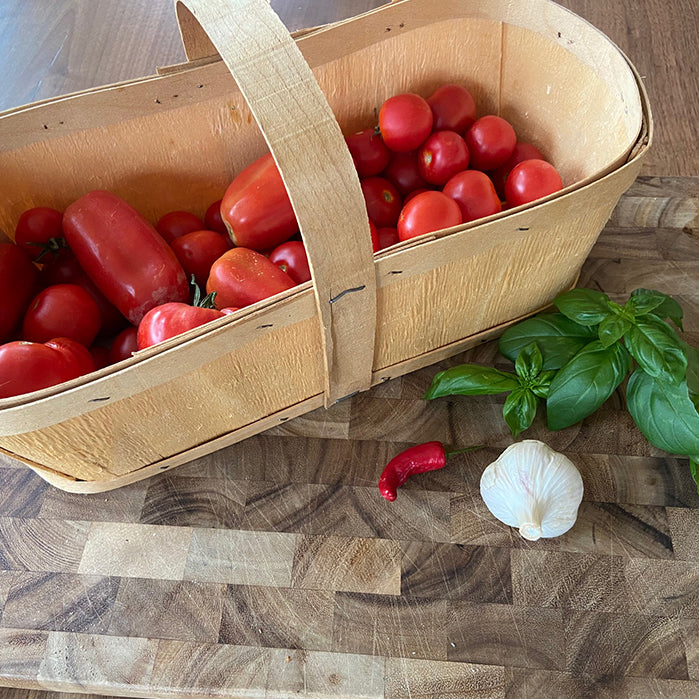 Basket of tomatoes, garlic, basil and hot peppers